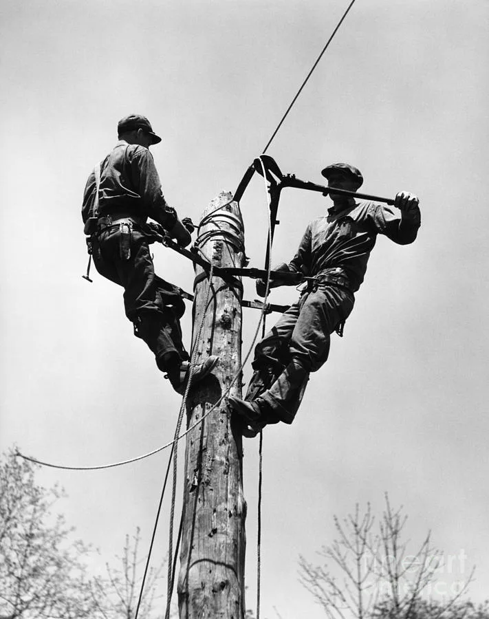 Linemen climbing a power pole, 1930s