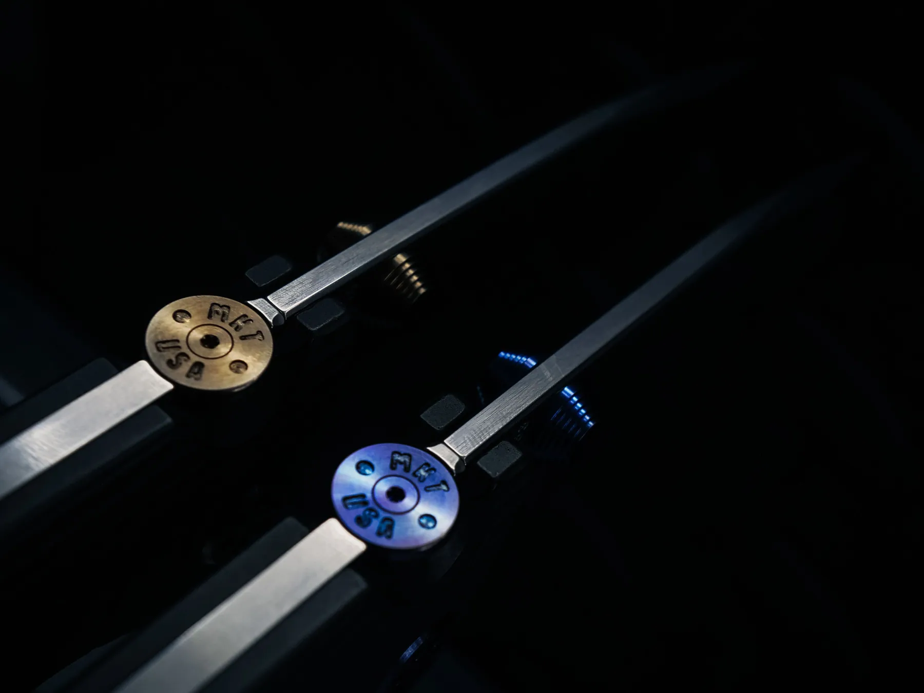 Blue and bronze pivot hardware on two Torrent knives